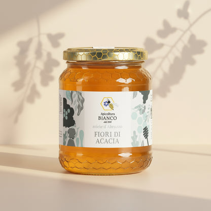 Jar of acacia honey with a white label on a white background